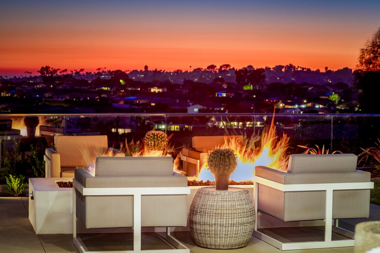 Hillside terrace with fire tables overlooking the city at dusk