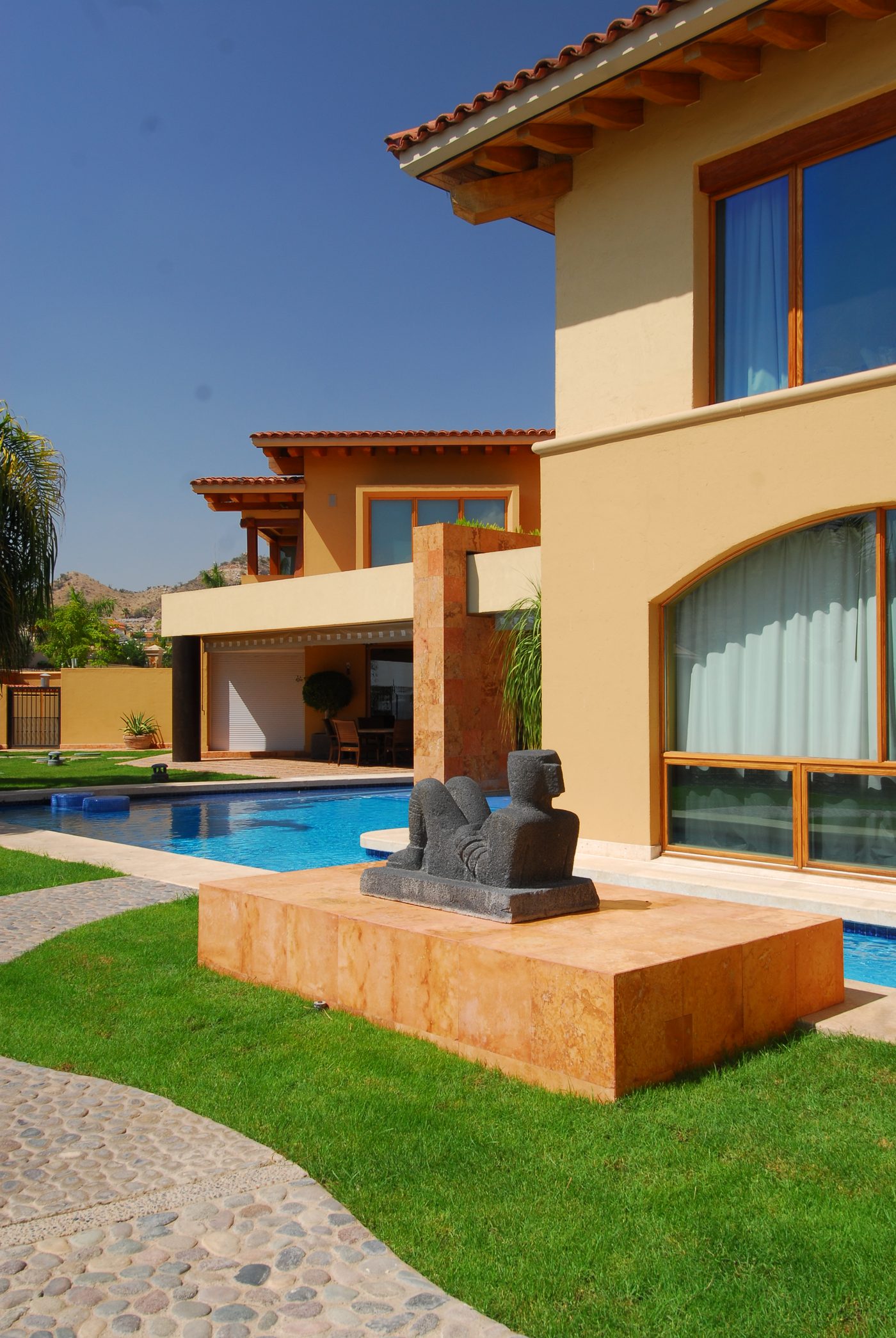 Pool alongside the terrace, with the stone pier and the tile frieze above