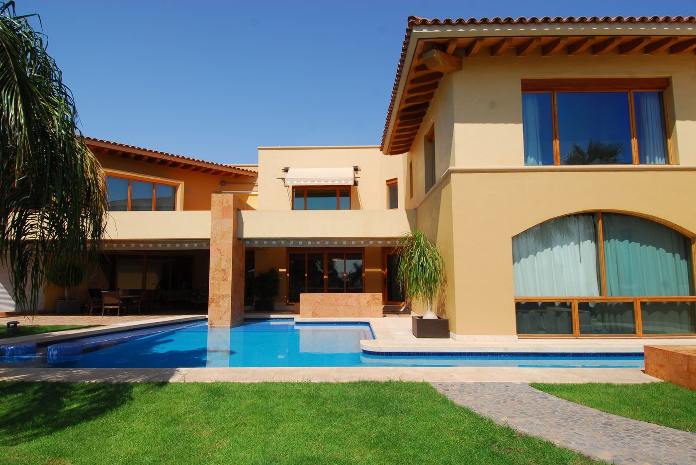 Garden face of the house with the pool along the covered terrace