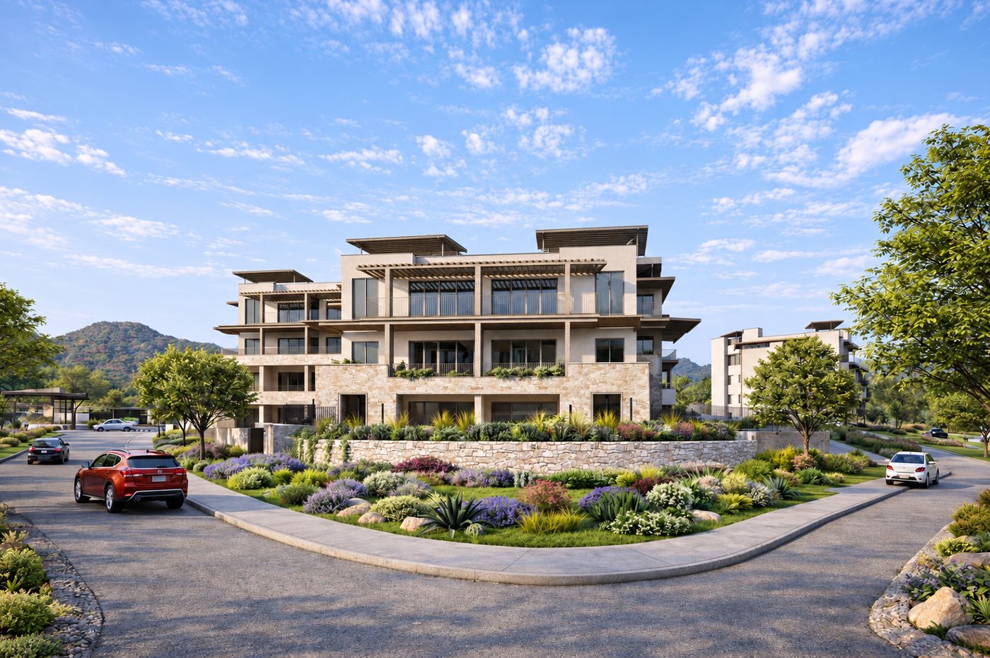 Arrival to the complex with a planted median, stone retaining walls and the hills behind