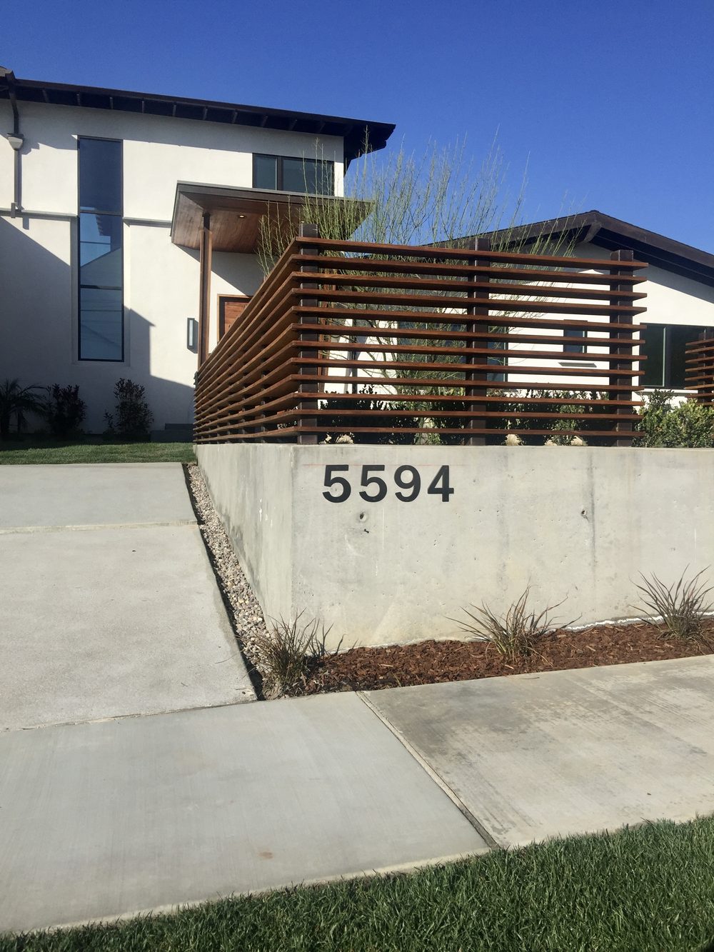 Street face of the house with its timber screen and the house number on the wall