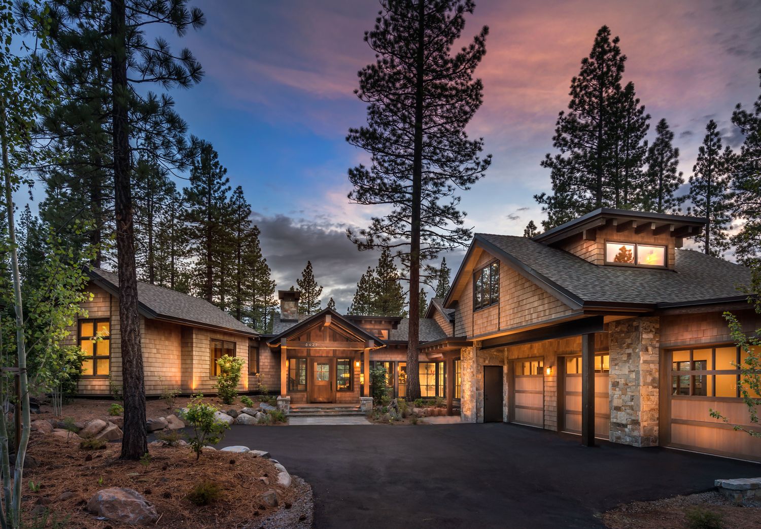 Mountain residence at dusk, timber and stone, among pines