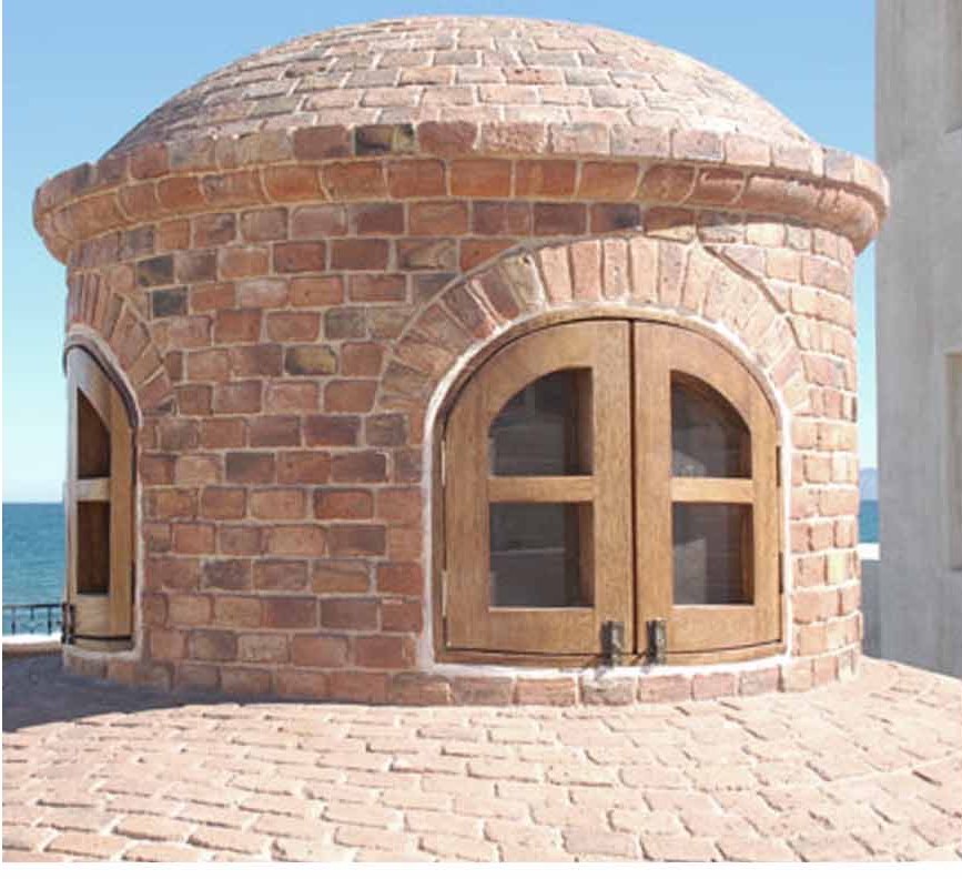 Brick cupola with timber doors, the sea behind it