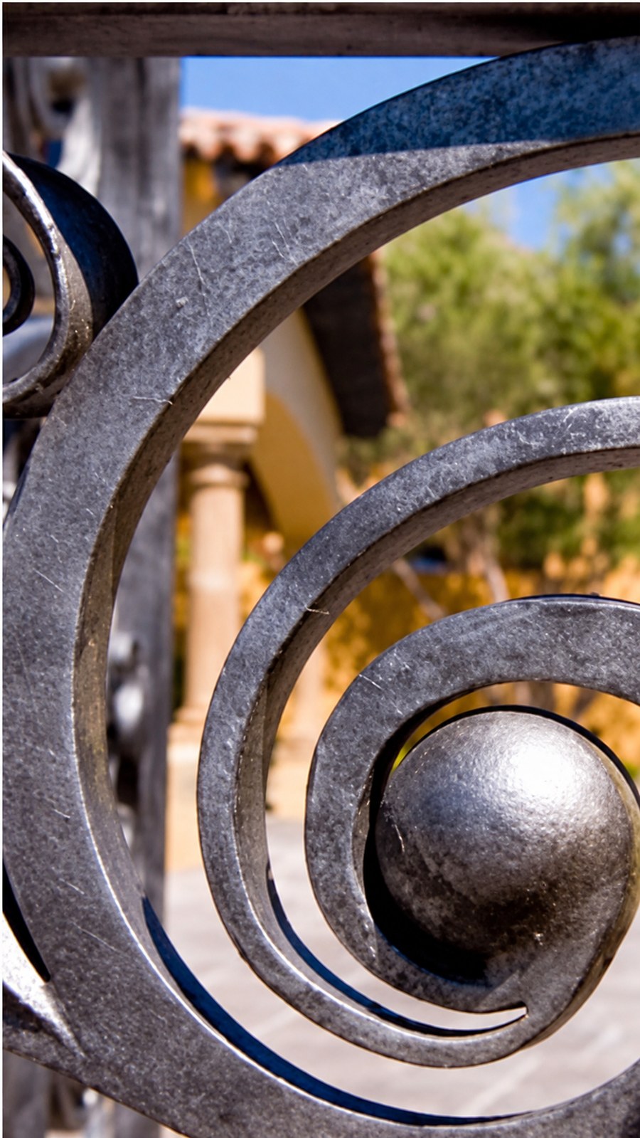 Forged iron spiral with its rivet, the house soft behind it